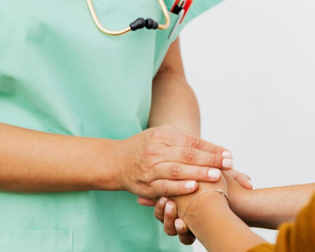 Healthcare professional comforting patient hands